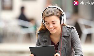Nuori tyttö kuulokeet päässään katsoo tablettia
