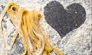 Kotitekoista pastaa ja sydämen muotoiltu jauhoilla pöydälle