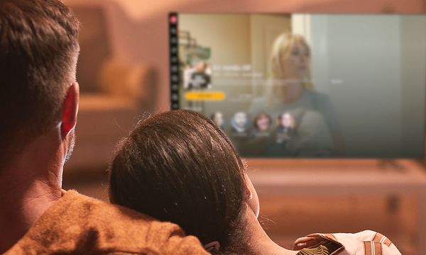 Mies ja tyttö katsovat televisiota
