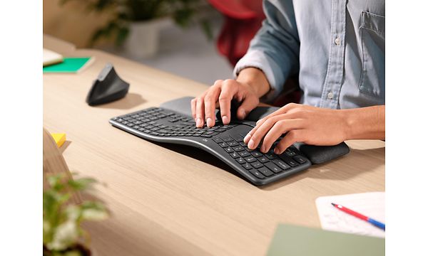 Kädet ergonomisen näppäimistön päällä