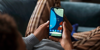 Fairphone 4 sohvalla makaavan henkilön kädessä