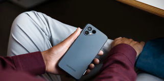 Fairphone 4 istuvan henkilön kädessä