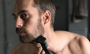 Mies trimmaa partaansa Philips OneBlade Pron avulla