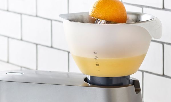 Kenwood-yleiskone keittiön työtasolla, johon on kiinnitetty mehustin