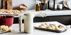 Kermanvärinen KitchenAid sähkövatkain, jonka vieressä on leivonnaisia