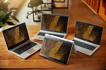 Neljä HP EliteBook -kannettavaa puupöydällä