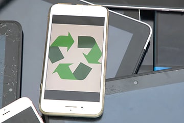 Valkoinen matkapuhelin vihreällä kierrätyssymbolilla