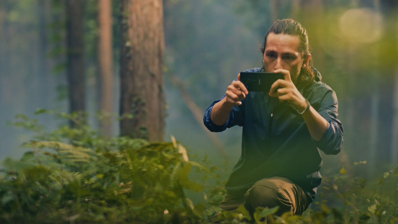 Mies kuvaa metsässä Sony Xperia PRO-I -puhelimella