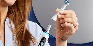 Nainen vaihtaa harjaspäätä Oral-B-sähköhammasharjaan
