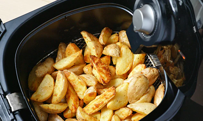 Lohkoperunoita airfryer-laitteen kypsennyskorissa