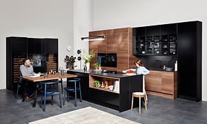 Mustan ja pähkinäpuun värinen EPOQ Edge keittiö avokeittiöratkaisulla, ruokailuryhmä ja keittiösaarreke