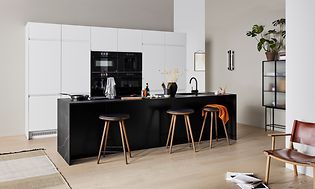 Moderni keittiö valkoisilla EPOQ Integra -sarjan ovilla, musta Integra-keittiösaarreke sekä baarituoleja