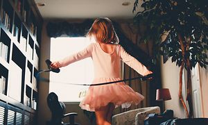Lapsi tanssii vaaleanpunaisessa balettiasussa