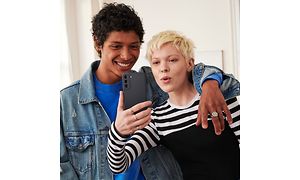 Nainen ja mies ottamassa selfie-kuvaa Samsung Galaxy S21 FE -puhelimella