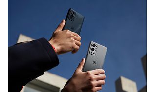 Kaksi OnePlus 9 -puhelinta korkealle nostettuna