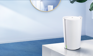 Valkoinen TP-Link  Deco X90 -mesh-järjestelmä pöydällä sinisessä huoneessa