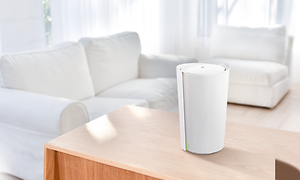 Valkoinen TP-Link Deco X90 -mesh-järjestelmä puisella pöydällä