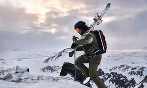 Garmin Fenix 6 suksia kantavan miehen ranteessa.