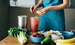 Nainen tekee banaani-mansikka-smoothieta tehosekoittimella