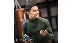 Mies ja Jabra Elite 4 Active kuulokkeet sekä puhelin kädessä