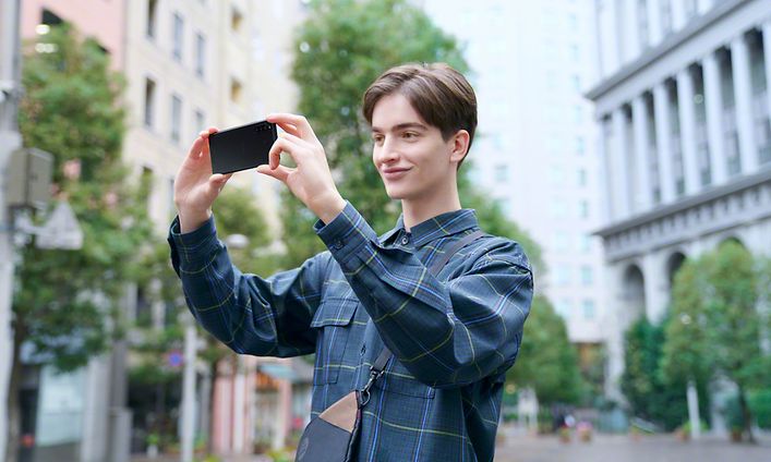 Nuori mies kuvaa kaupunkia Sony Xperia -puhelimella