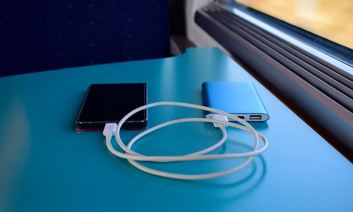 Junan pöydällä oleva puhelin käyttää varavirtalähdettä lataukseen