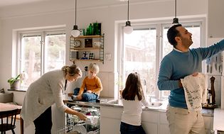 MDA - Astianpesukoneet - Perhe tyhjentää keittiössä olevaa astianpesukonetta yhdessä