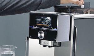 Henkilö laittaa puhdistustablettia Siemens-espressokeittimeen