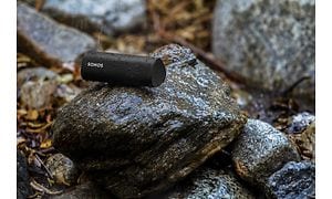Musta Sonos Roam SL märän kiven päällä sateisessa säässä