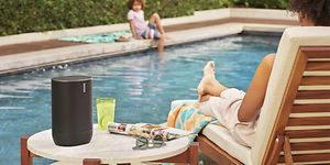 Sonos Move -kaiutin altaan reunalla istuvan naisen vieressä