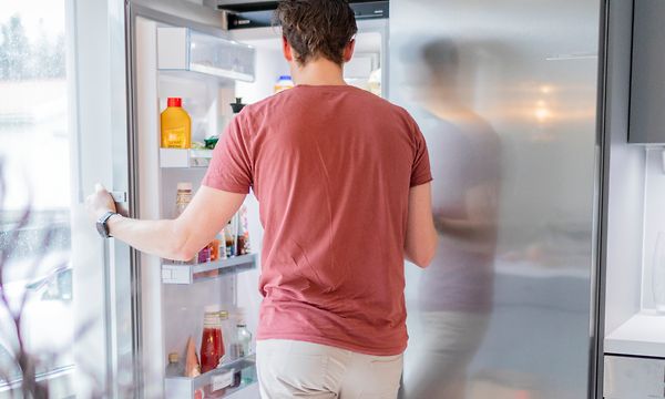 Mies avaamassa teräksisen pakastimen ovea
