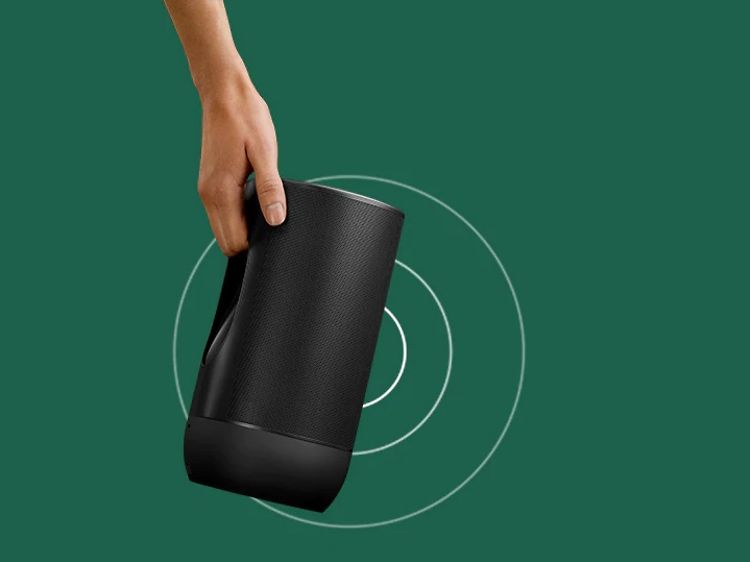 Henkilö kantaa Sonos Move-kaiutinta kädessään