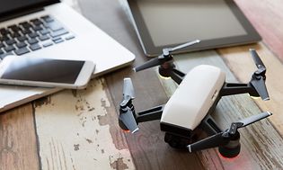 Drone tietokoneen ja tabletin vieressä