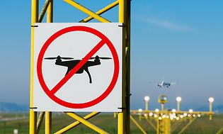 Lentokentän kiitorata sekä dronet alueella kielletty -merkki