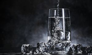 Lasillinen kuplivaa vettä jääpaloilla