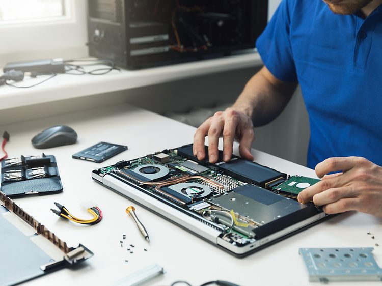 Tietokoneet - Mies korjaa kannettavan tietokoneen SSD-levyä