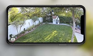 Älypuhelin näyttää Arlo-kameran kuvaa puutarhasta