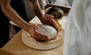 Kädet pitelemässä leivottua leipää
