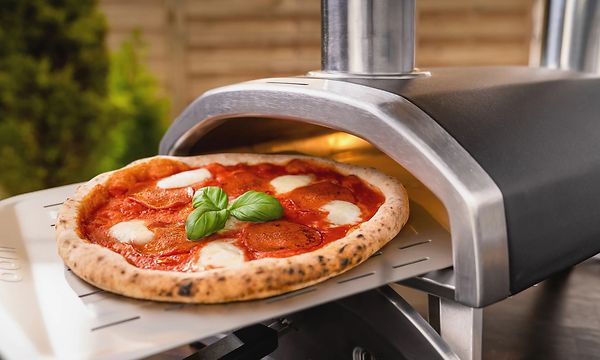 Pizza liukumassa pizzauunin sisään