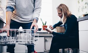 Pariskunta keittiössä astianpesukoneen vieressä