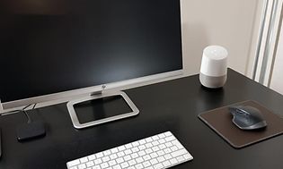 Google Home työpöydällä tietokoneen vieressä