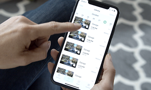 Henkilö tarkastelee Arlo-sovellukseen tallennettuja turvakameran videoita