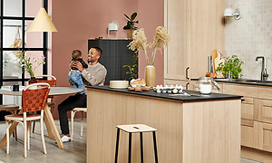 Mies ja vauva istuvat Natural Oak -puukuvioisessa Epoq Shaker -keittiössä
