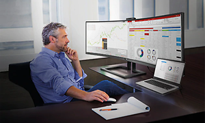 Computing - home office - Man in office with wide PC screen - 630x400
