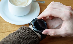 Telecom - smart watch - Person checking smart watch whilst drinking coffee - 630x420