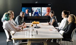 Kokoushuone jossa kokoukseen osallistujia ja Konftel-videokokousratkaisu pöydällä,