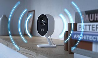 Arlo Essential Indoor Camera-kamera ja kuvitus sireenin ääniaalloista sen ympärillä