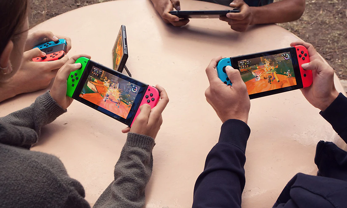 Nintendo Switch Lite - neljä henkilöä pelaavat yhdessä kannettavilla pelikonsoleilla