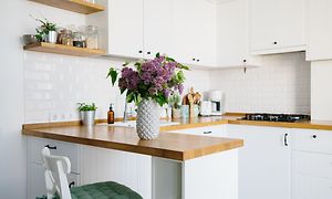 Pienikokoinen  keittiö, jossa on kukkamaljakko työtasolla