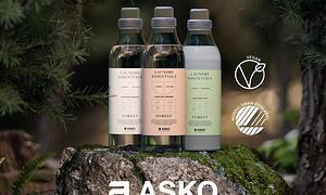 Asko-pesuainepullot kuvattuna metsässä